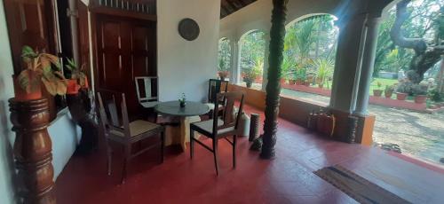 a room with a table and chairs and a window at Kallupurackal Heritage Island Home By Lexstays in Alleppey
