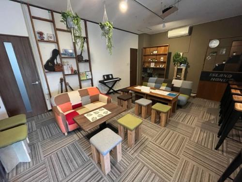 a living room with a couch and a table and chairs at IslandHonu in Ishigaki Island