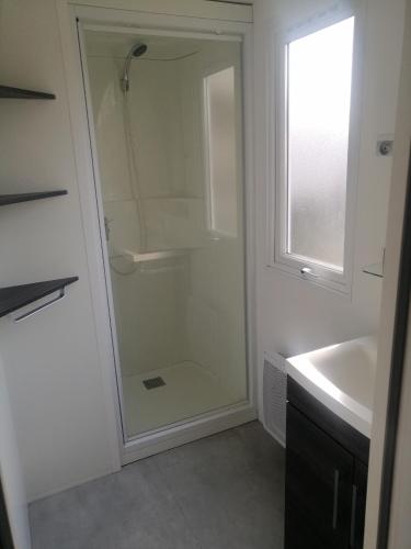 une salle de bain avec une douche en verre et un lavabo dans l'établissement SAS MHVACANCES LOUE MOBILHOME 2 CHAMBRES PROCHE CHATEAUX et ZOO BEAUVAL, à Onzain