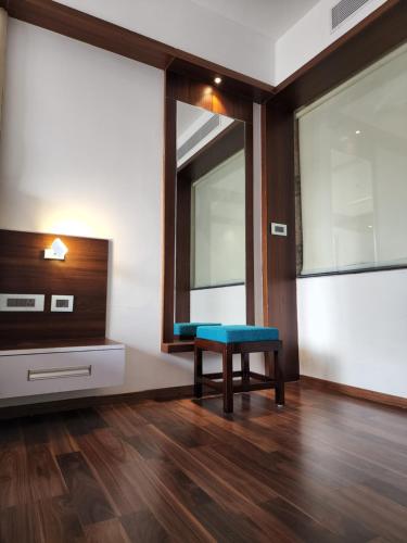 a living room with a bench and a tv at Hotel Preethi International in Mysore