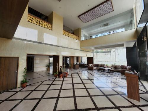 a large lobby with couches and tables in a building at Hotel Preethi International in Mysore