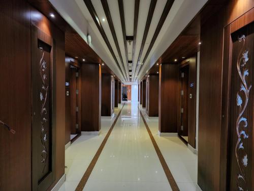 a hallway in a building with wooden doors at Hotel Preethi International in Mysore