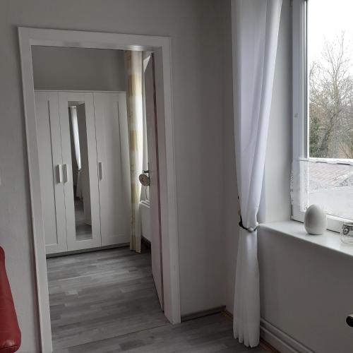 an empty room with a window and a mirror at Bi uns im Norden in Brunsbüttel