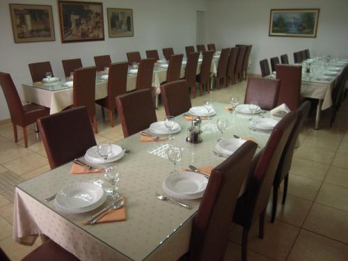 a dining room with tables and chairs with plates and wine glasses at Guest House Regina Mundi in Međugorje