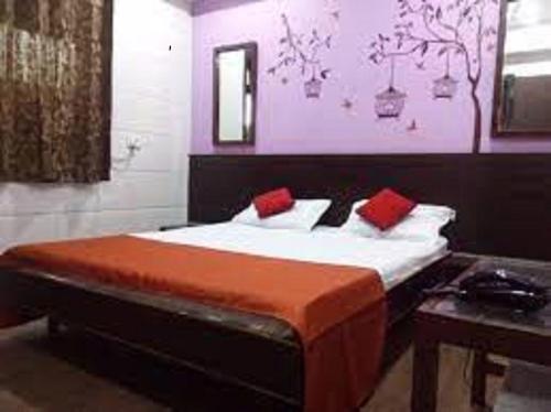 a bedroom with a large bed with red pillows at Hotel Geetanjali St Bus Stand Panvel in Panvel