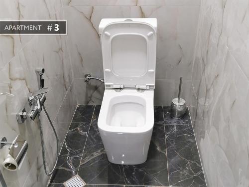 a bathroom with a white toilet in a stall at Bereket villa and aparts in Gabala