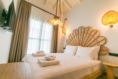 a hotel room with a bed with two towels on it at Kotraba Alacati Hotel in Alacati