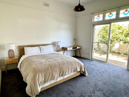 - une chambre avec un lit et une grande fenêtre dans l'établissement Beach Rd Kids & Pet Friendly Free Parking, à Mordialloc