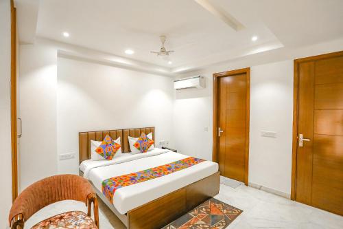 a bedroom with a bed and a wooden door at FabExpress Aerosky Deluxe in New Delhi