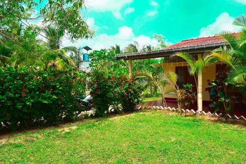 a house with a grass yard next to a building at Beach Walk Villa in Trincomalee