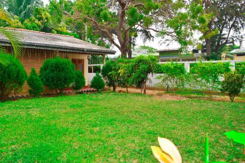 a yard with a house and a yard sidx sidx sidx at Beach Walk Villa in Trincomalee