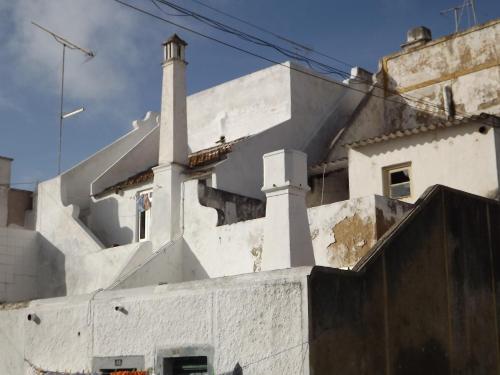 a white building with two chimneys on top of it at EntreCubos Guesthouse in Olhão