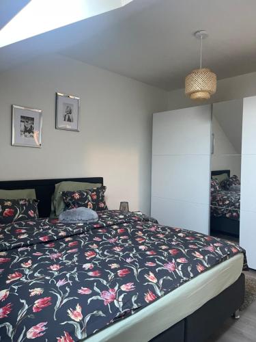1 Schlafzimmer mit einem Bett mit Blumenbettdecke in der Unterkunft Le cocon de la belle liégeoise in Lüttich