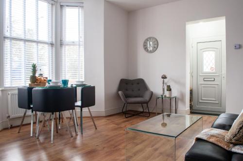 uma sala de estar com uma mesa e um sofá em Bedford Rd Apartment Ideal for Hospital & Town Centre em Kempston