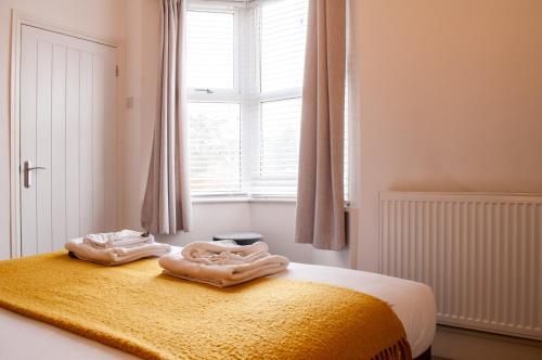 a bedroom with a bed with two towels on it at Bedford Rd Apartment Ideal for Hospital & Town Centre in Kempston