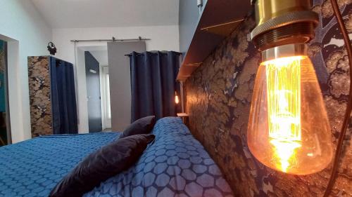 a bedroom with a blue bed with a light on it at Les Appartements du 104 in Saint-Jean-de-Monts