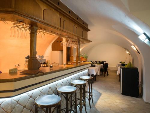 a bar with stools in a restaurant with tables at Hotel City Pisek in Písek