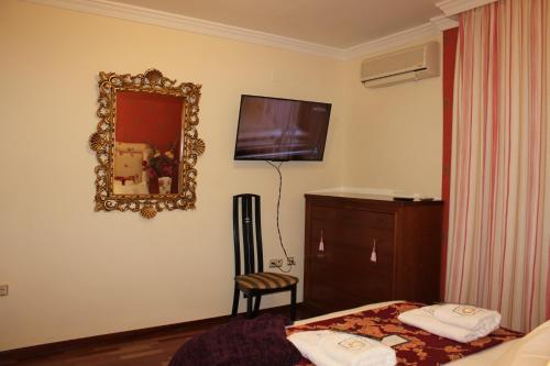a bedroom with a mirror and a bed and a chair at Villa Granada Motril in Motril