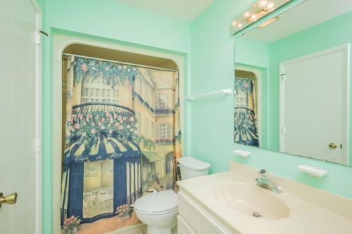a bathroom with a sink and a toilet and a mirror at 9th Tee in Caswell Beach