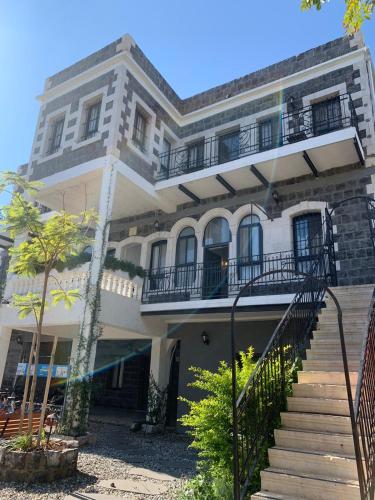 a large white building with stairs in front of it at magic rose קסם הורד in Tiberias