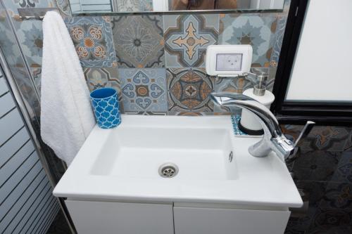 a white sink in a bathroom with a tile wall at magic rose קסם הורד in Tiberias