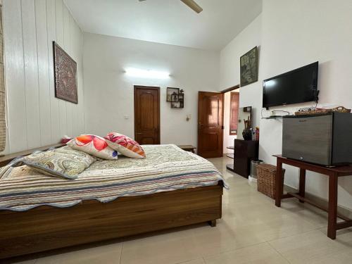 a bedroom with a bed with pillows and a television at Luxurious Homestay- Chandīgarh in Chandīgarh