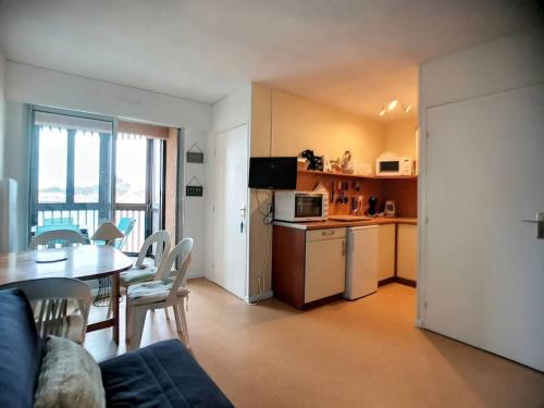 un salon avec une cuisine et une table et des chaises dans l'établissement V-Landes 01-Vieux Boucau Appartement dans résidence avec piscine au bord du lac marin, à Vieux-Boucau-les-Bains