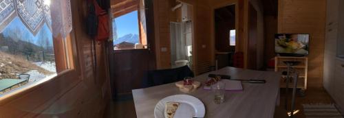Habitación pequeña con mesa y ventana en Camping & Chalet Pian della Regina, en Cevo