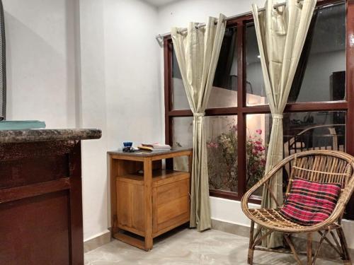 a room with a chair and a table and a window at GOVARDHAN HOME STAY ( Munna ) in Guwahati