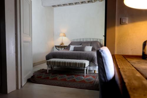 a bedroom with a bed with a bench in it at Maison de la Pra in Valence