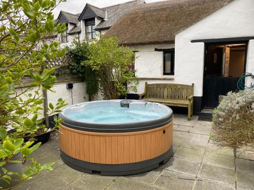a hot tub in the yard of a house at Poyers Farmhouse in Wrafton