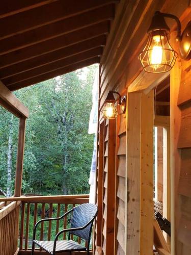 a porch with two chairs and two lights on it at The Eagle's Nest Treehouse Cabin in Palmer