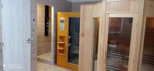 Pokój z drewnianymi drzwiami i szklanymi drzwiami w obiekcie Robitel Wellness Vendégház Veszprém-Gyulafirátót w mieście Veszprém
