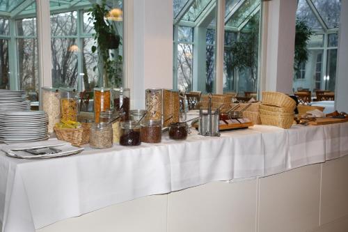 a white table with plates and baskets on it at Albhotel Fortuna in Riederich