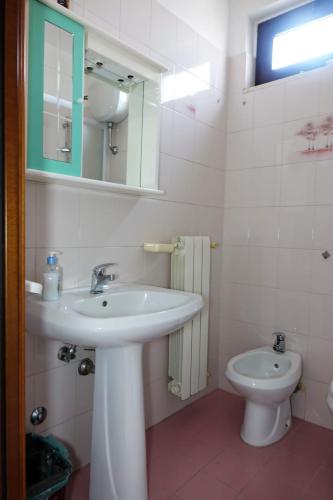 a white bathroom with a sink and a toilet at Casa Mary in Lavello
