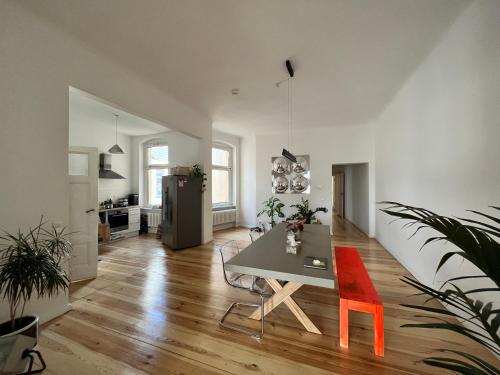 a dining room with a table and a red chair at Dreamy Apartment in Kreuzberg - 130m2 in Berlin