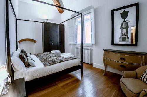 sypialnia z łóżkiem z baldachimem i komodą w obiekcie Borgo San Jacopo Deluxe by 360Rentals we Florencji