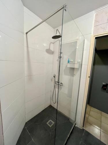 une douche avec une porte vitrée dans une salle de bain dans l'établissement Aubervilliers maison de ville près métro 7 by immo kit bnb, à Aubervilliers
