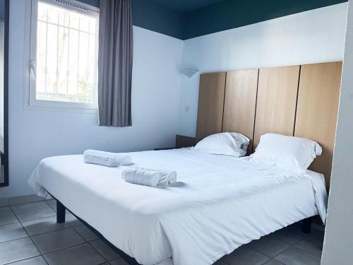 une chambre avec un grand lit blanc avec des serviettes dessus dans l'établissement Appartement 301 avec deux chambres - LES SUITES DE ROBINSON - Résidence avec piscine en bord de Siagne, à Mandelieu-La-Napoule, à Mandelieu-la-Napoule