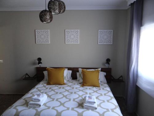 - une chambre avec un lit et des oreillers jaunes dans l'établissement B&B Casa Sarandy, à Almogía