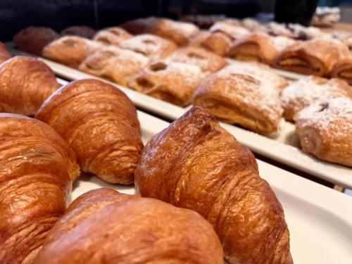 a bunch of croissants and other pastries on trays at CHALET VILLAGE ZAGLGUT Wellness & Views with Summer Card Included in Kaprun