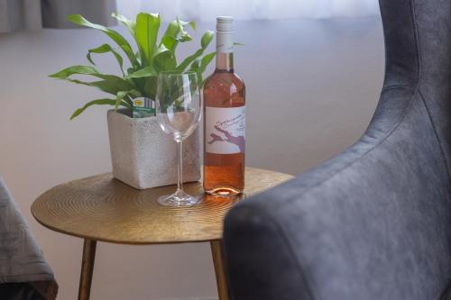 a bottle of wine and a glass on a table with a plant at Boardinghouse HOME - adults only - in Konstanz