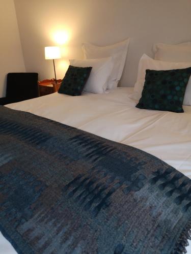 a large white bed with two pillows on it at Les Enclos Bed and Breakfast à 4 mn de Chantilly in Lamorlaye