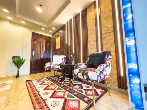 two chairs and a table in a room with a rug at Luxury two bedroom شقة فخمة وكبيرة غرفتين in Ajman