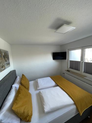 a bedroom with a large white bed with yellow pillows at Altstadt Hotel Self Check-In in Würzburg