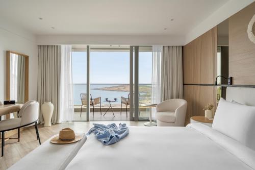 a hotel room with a bed with a view of the ocean at METT Hotel & Beach Resort Bodrum in Bodrum City