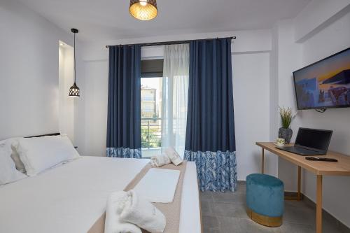 1 dormitorio con 1 cama y escritorio con ordenador portátil en GreyStoneApartments, en Paralia Dionisiou