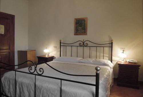 a bedroom with a large bed with two night stands at Il Vecchio Mulino in Volterra
