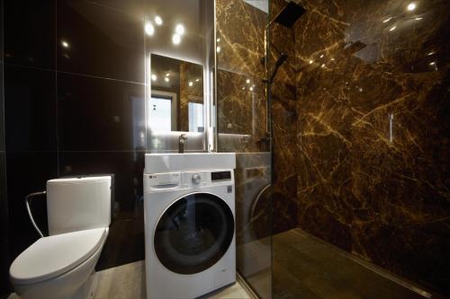 ein Badezimmer mit einer Waschmaschine und einem WC in der Unterkunft Loft 3 rooms riverside by Gauja.Club - Residences in Gauja