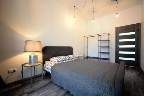 a bedroom with a bed and a lamp and a ladder at Loft 3 rooms riverside by Gauja.Club - Residences in Gauja